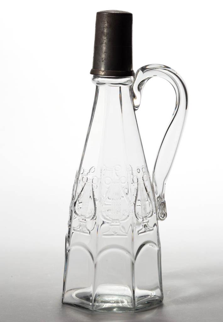 HARP / LYRE SYRUP CAN: HARP / LYRE SYRUP CAN, colorless lead glass, blown-molded conical eight-panel form with molded neck ring and applied hollow handle, mouth ground to accept a standard Britannia nozzle, period Britannia