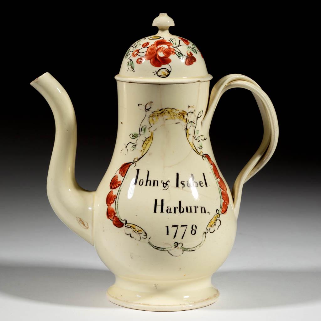 ENGLISH CREAMWARE CERAMIC MARITAL COFFEE POT: ENGLISH CREAMWARE CERAMIC MARITAL COFFEE POT, pear-shaped with domed cover and double twisted handle, featuring polychrome hand-painted overglaze enamel decoration of a woman milking a horned cow with