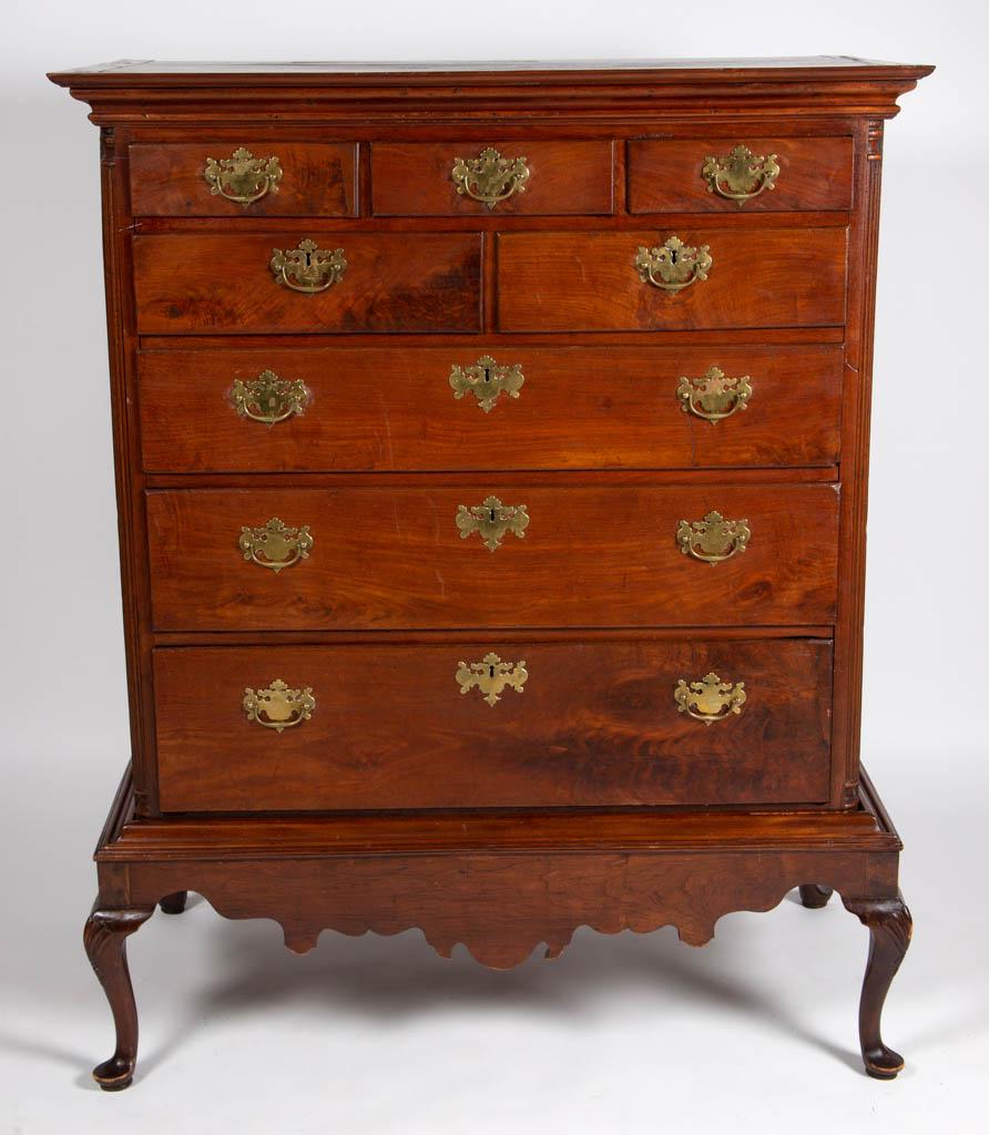 PENNSYLVANIA FIGURED WALNUT CHEST ON FRAME: PENNSYLVANIA FIGURED WALNUT CHEST ON FRAME, applied molded cornice, three-over-two-over-three thumb-molded drawers, flanked by fluted quarter columns, solid ends, raised on a separate frame with scrol