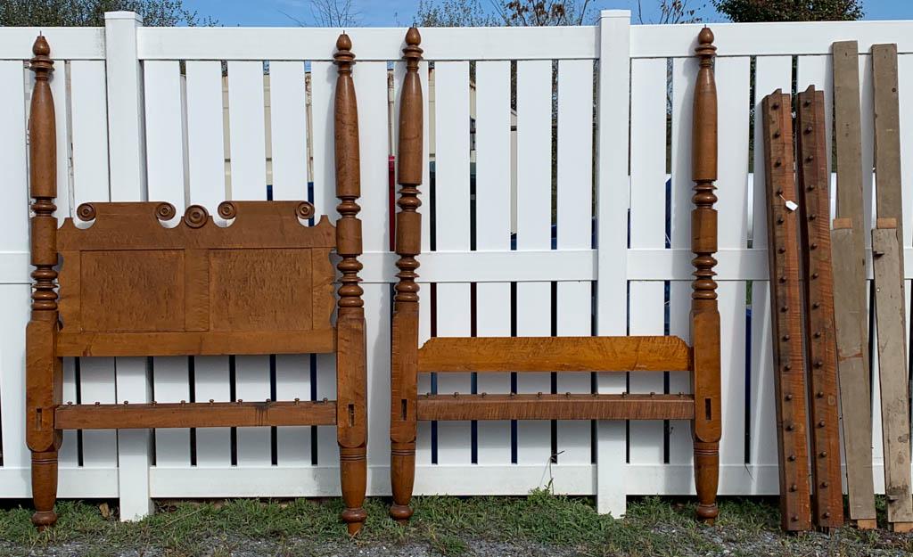 MID-ATLANTIC FIGURED MAPLE POSTER BED: MID-ATLANTIC FIGURED MAPLE POSTER BED, ring- turned posts, shaped-headboard with elaborate carvings, hardware present. Retains an old surface with warm color. Circa 1825. Headboard 49 1/4" W, 85" HOA.