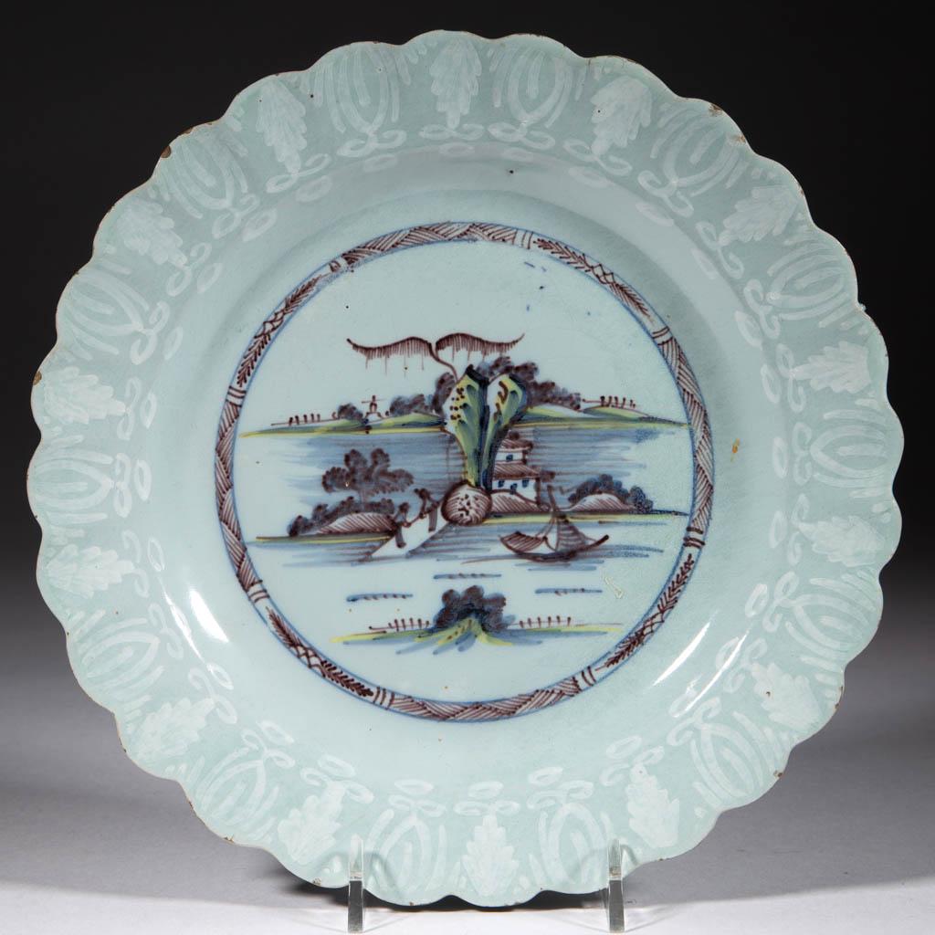 ENGLISH DELFT BIANCO SOPRA BIANCO TIN-GLAZED: ENGLISH DELFT BIANCO SOPRA BIANCO TIN-GLAZED EARTHENWARE PLATE, featuring a central polychrome Chinoiserie hand-painted motif featuring a coastal scene with island, sailboat, and two figures on dock, 