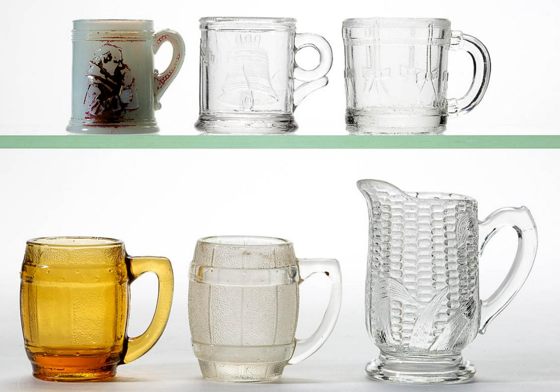 ASSORTED PRESSED CHILDREN: ASSORTED PRESSED CHILDREN'S GLASS TOY MUGS, LOT OF FIVE, colorless, amber, and opaque white with fiery opalescence, comprising a Liberty Bell, a Drum, two Barrels, and a Monk. Together with a colorles