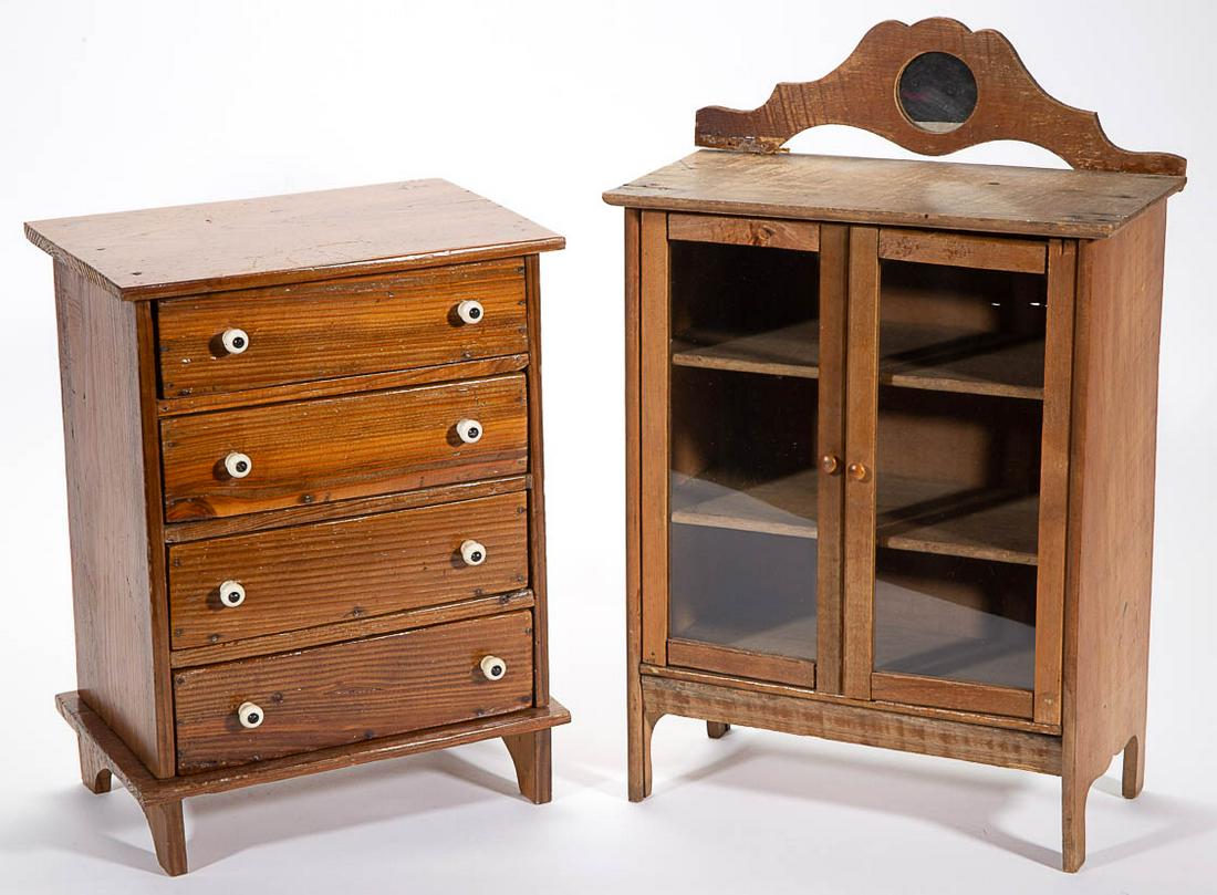 WOODEN CHILD: WOODEN CHILD'S / DOLL FURNITURE, LOT OF TWO, comprising a maple display cabinet with glass-front doors, fixed interior shelves, and an applied mirror to top, and a pine chest of drawers. First half 20