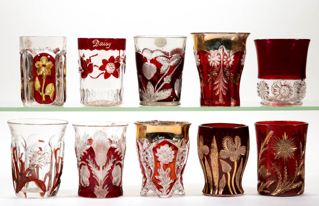 ASSORTED EAPG - RUBY-STAINED TUMBLERS, LOT OF TEN: ASSORTED EAPG - RUBY-STAINED TUMBLERS, LOT OF TEN, colorless, some with gilt or amber-stained decoration, including a McKee's Puritan, a Sunflower Patch, a Japanese Iris, and an Inverted Strawberry. L