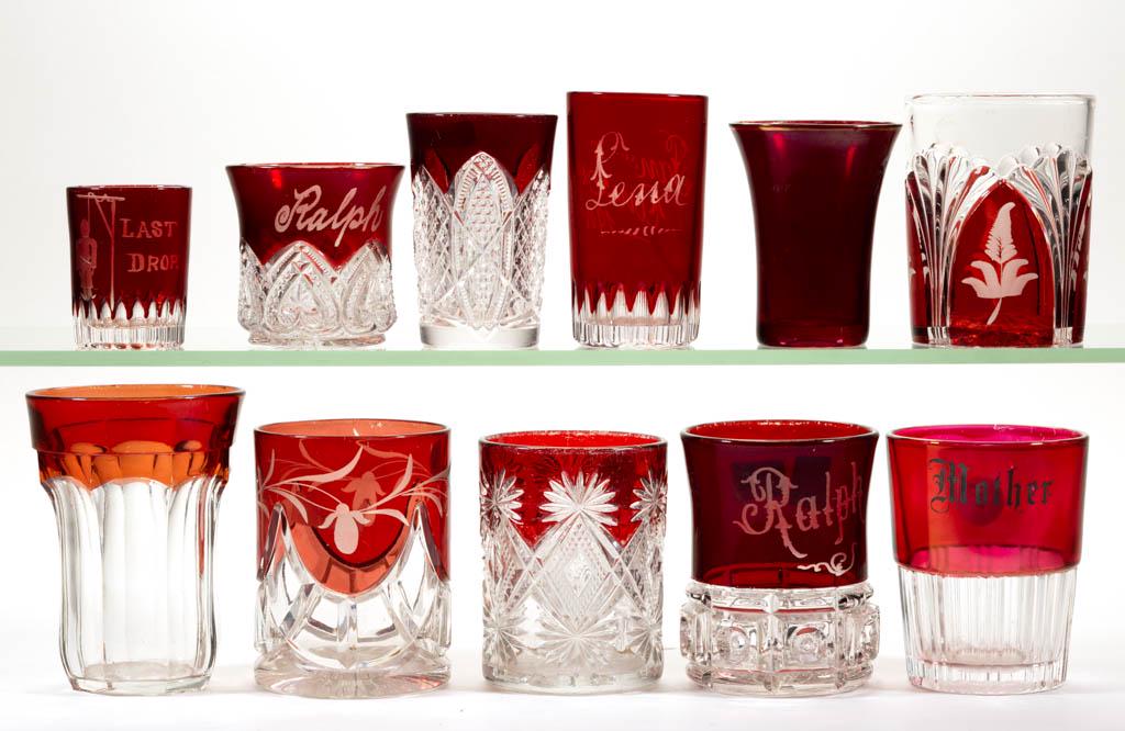 ASSORTED EAPG - RUBY-STAINED TUMBLERS AND OTHER: ASSORTED EAPG - RUBY-STAINED TUMBLERS AND OTHER ARTICLES, LOT OF TEN, colorless, some with souvenir/personalized decoration, including a shot glass engraved with "LAST DROP", a "Pan Am. Expo 1901" jui