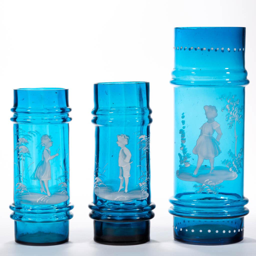 VICTORIAN PANEL-OPTIC MARY GREGORY (SO-CALLED): VICTORIAN PANEL-OPTIC MARY GREGORY (SO-CALLED) RING-NECK CYLINDER VASES, LOT OF THREE, blue with white polychrome-enamel decoration, each depicting a Victorian child in a different pose. Boston & Sand