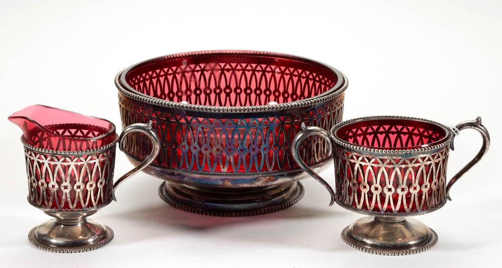 ASSORTED VICTORIAN GLASS ARTICLES, LOT OF THREE: ASSORTED VICTORIAN GLASS ARTICLES, LOT OF THREE, cranberry, comprising a bowl, creamer, and spooner, each fitted into matching silver-plated bases. Various makers. Late 19th/early 20th century. 3 5/8"