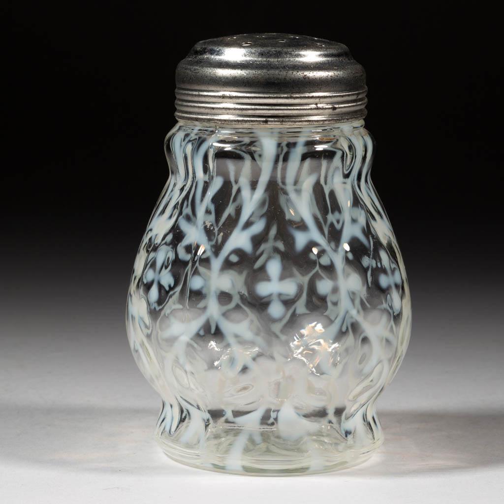 OPALINE BROCADE / SPANISH LACE SUGAR SHAKER: OPALINE BROCADE / SPANISH LACE SUGAR SHAKER, colorless opalescent, period lid. Northwood Glass Co. Pattern introduced 1899. 4 1/2" H.Excellent condition with a single bruise to the interior of the mou