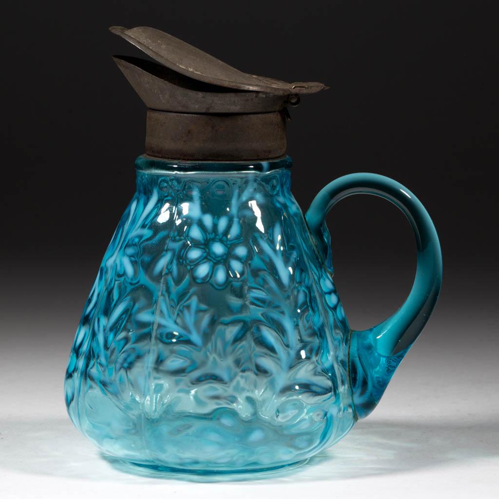 DAISY AND FERN - W. VA OPTIC MOLD SYRUP PITCHER: DAISY AND FERN - W. VA OPTIC MOLD SYRUP PITCHER, blue opalescent, blue applied handle, period lid. West Virginia Glass Co. Late 19th/early 20th century. 5 1/2" HOA. Glass undamaged; lid having one sid