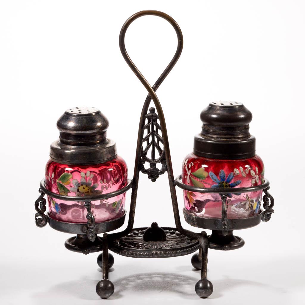 SPOT-OPTIC AND ENAMEL-DECORATED SALT AND PEPPER SET: SPOT-OPTIC AND ENAMEL-DECORATED SALT AND PEPPER SET, cased cranberry with matching polychrome-enamel decoration, each square form with floral decoration, each with period two-part lids, fitted into a 