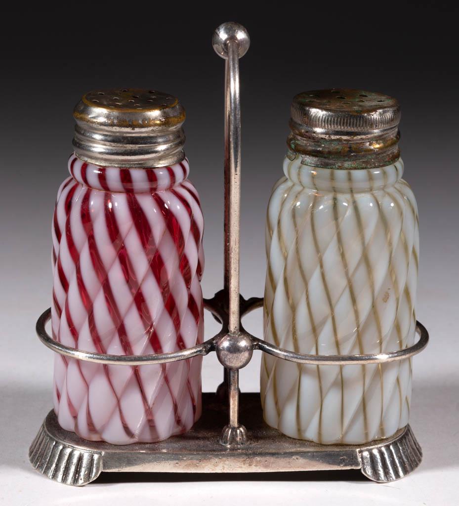 REVERSE SWIRL SALT AND PEPPER SET: REVERSE SWIRL SALT AND PEPPER SET, cranberry and Vaseline (reacts under black light) opalescent, period lids, fitted into a quadruple-plated stands marked for "PAIRPOINT MFG. CO." and numbered "732". 
