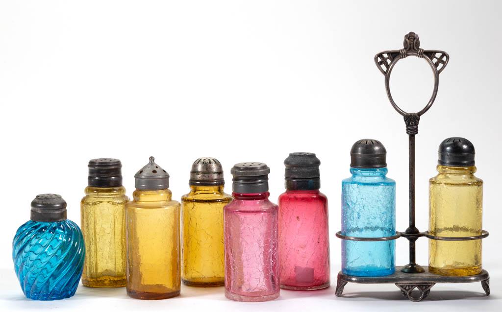 ASSORTED CRACKLE-TYPE GLASS SALT AND PEPPER SHAKERS,: ASSORTED CRACKLE-TYPE GLASS SALT AND PEPPER SHAKERS, LOT OF EIGHT, amber, blue, and cranberry, each with period lid. Together with a silver-plated stand by Pairpoint Mfg. Co. Nine pieces total. Variou
