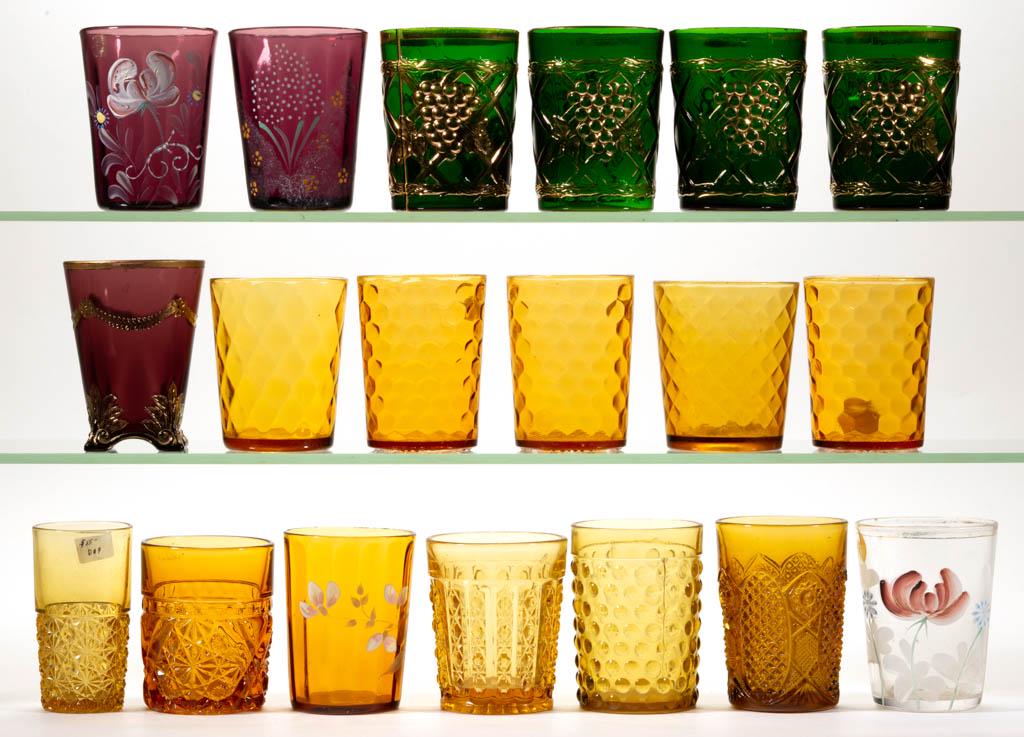 ASSORTED TUMBLERS, LOT OF 18: ASSORTED TUMBLERS, LOT OF 18, amber, green, amethyst, and colorless, some with gilt or enamel decoration, including a set of four grapevine-patterned examples and a Klear-Kut. Together with an amber D
