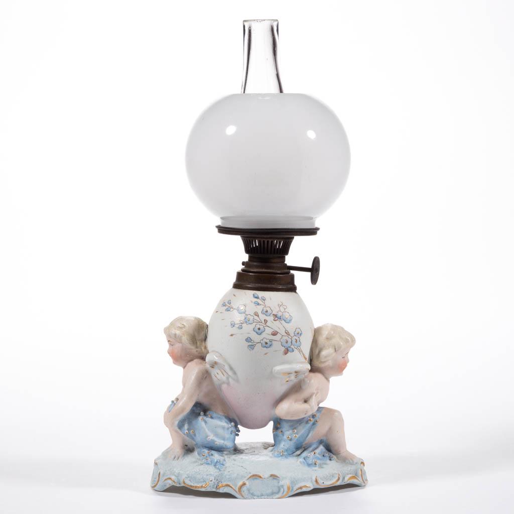 GERMAN BISQUE FIGURAL MINIATURE LAMP: GERMAN BISQUE FIGURAL MINIATURE LAMP, multi-colors in pastels, depicting two sitting cherubs with their backs supporting an egg-form font, scroll and textured base; alabaster/clambroth ball-form shade