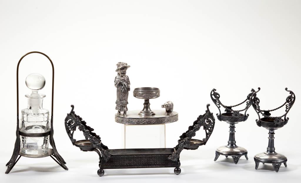 ASSORTED QUADRUPLE-PLATE STANDS, LOT OF FIVE: ASSORTED QUADRUPLE-PLATE STANDS, LOT OF FIVE, including a Kate Greenaway figural, a trough with side cups, and a foliate holding a colorless and engraved perfume bottle with a spherical stopper. Vario