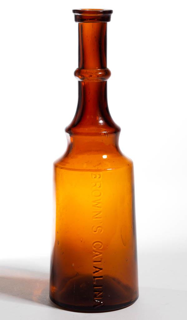 BROWN'S CATALINA FIGURAL BITTERS / MEDICINE BOTTLE: BROWN'S CATALINA FIGURAL BITTERS / MEDICINE BOTTLE, medium golden amber, cylindrical modified lighthouse or cannon barrel, embossed "BROWN'S CATALINA" vertically, ring neck, applied heavy flanged, squ
