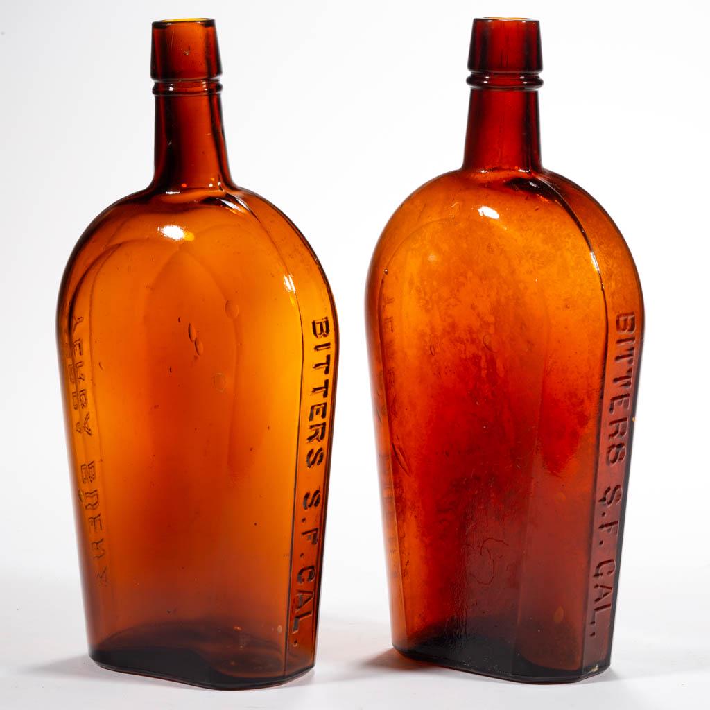YERBA VARIANT WESTERN BITTERS BOTTLES, LOT OF TWO: YERBA VARIANT WESTERN BITTERS BOTTLES, LOT OF TWO, golden amber, quart, each strap-side flask embossed "YERBA BUENA" and "BITTERS S. F. CAL." on sides, broad sloping mouth with lower collar, each base
