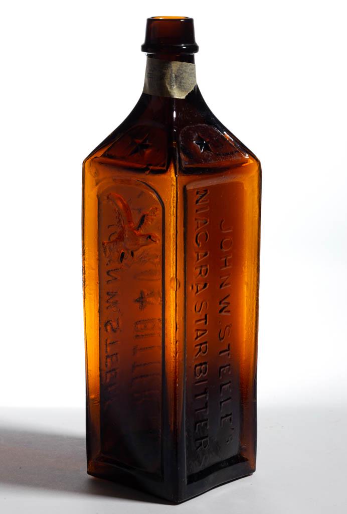STEELE'S NIAGARA BITTERS BOTTLE: STEELE'S NIAGARA BITTERS BOTTLE, medium golden amber, square form embossed on two sides "JOHN W. STEELE'S / NIAGARA (five-point star) BITTERS" and "JOHN W. STEEL'S / NIAGARA STAR BITTERS", third side