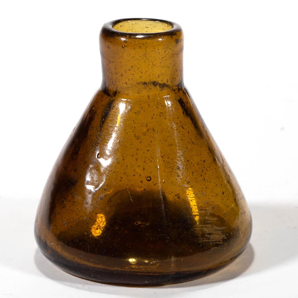 BLOWN-MOLDED CONE / CONICAL INK BOTTLE: BLOWN-MOLDED CONE / CONICAL INK BOTTLE, medium yellow olive amber, plain mouth, tubular pontil mark with embossed "X" to side. Probably Stoddard, New Hampshire. 1820-1850. 2 1/4" H, 2 1/8" D base. Und