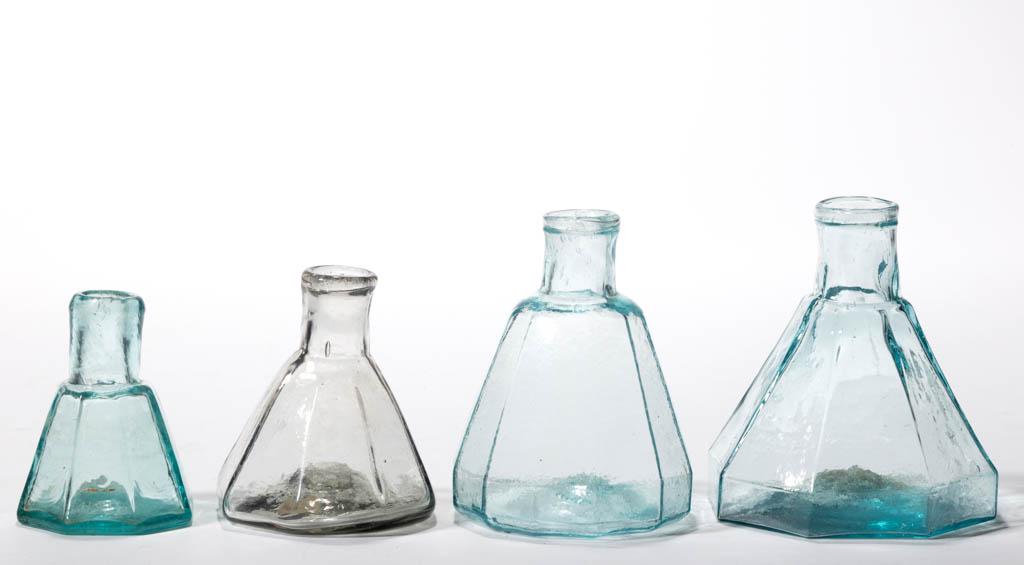 ASSORTED BLOWN-MOLDED UMBRELLA INK BOTTLES, LOT OF FOUR: ASSORTED BLOWN-MOLDED UMBRELLA INK BOTTLES, LOT OF FOUR, aquamarine and smoky colorless, comprising one 12-sided and three octagonal, each with tooled mouth and rough pontil mark. Circa 1850. 2 1/4" t