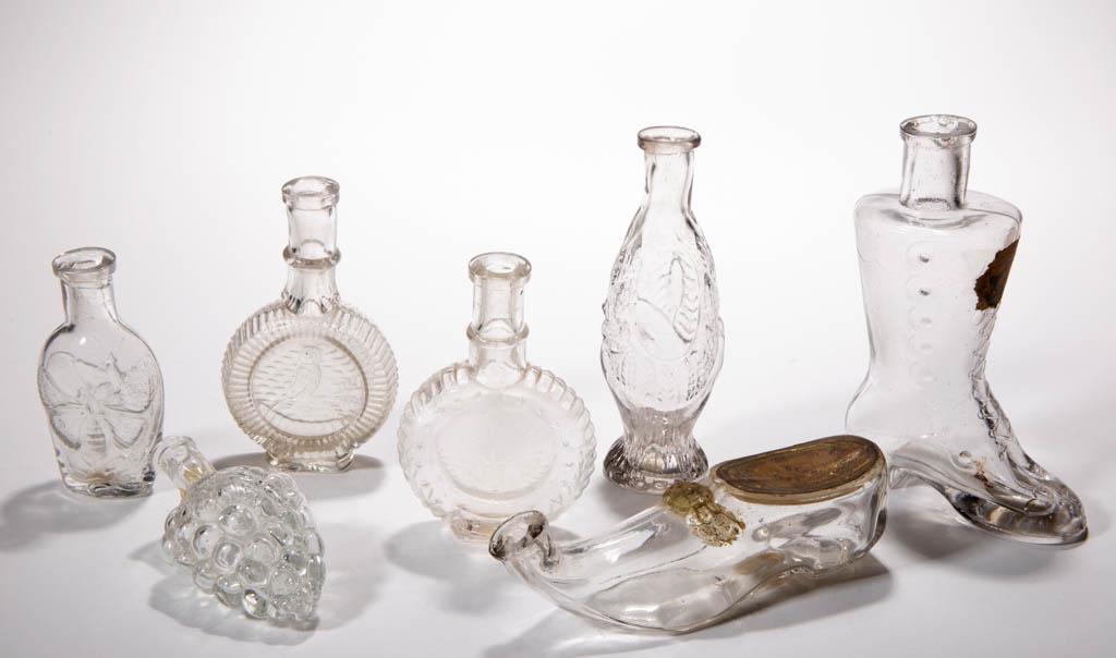 ASSORTED BLOWN-MOLDED FIGURAL COLOGNE / PERFUME: ASSORTED BLOWN-MOLDED FIGURAL COLOGNE / PERFUME BOTTLES, LOT OF SEVEN, colorless, including a circular example with owl seated on branch, a hand holding leaves, a button-up boot, and a slipper with or
