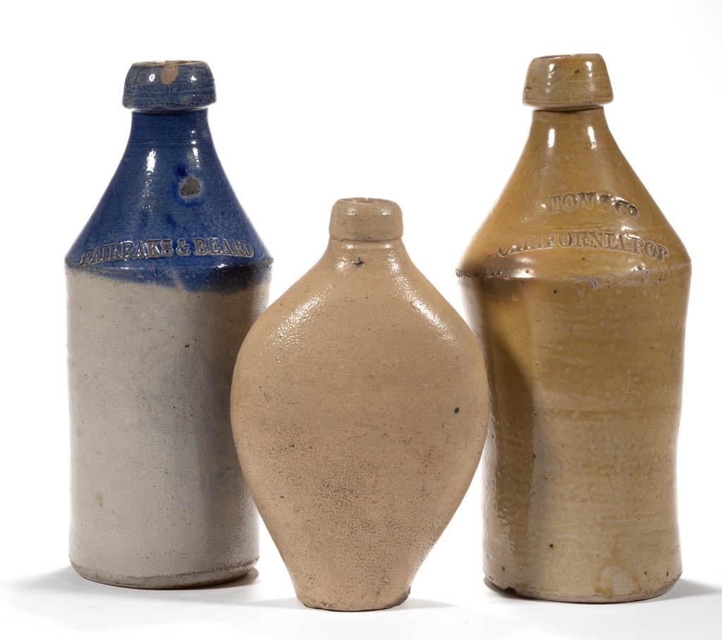 STAMPED STONEWARE SODA / BEER BOTTLES, LOT OF TWO: STAMPED STONEWARE SODA / BEER BOTTLES, LOT OF TWO, salt-glazed, each cylindrical form with sharp shoulder, grey example with brushed cobalt upper section stamped "FAIRBANKS & BEARD", tan example stamp