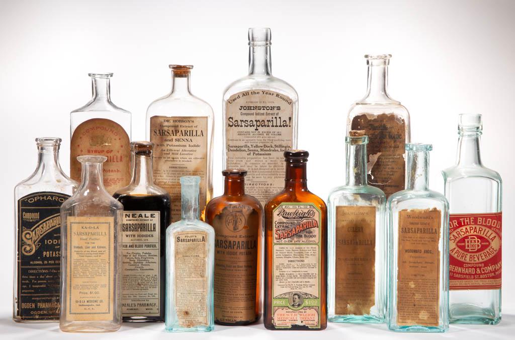 ASSORTED LABELED SARSAPARILLA BOTTLES, LOT OF 13: ASSORTED LABELED SARSAPARILLA BOTTLES, LOT OF 13, amber, aquamarine, and colorless, various forms, two with embossing, remainder labeled only, including Harlow's, Johnston's, Neale, Woodward's, Ejete,