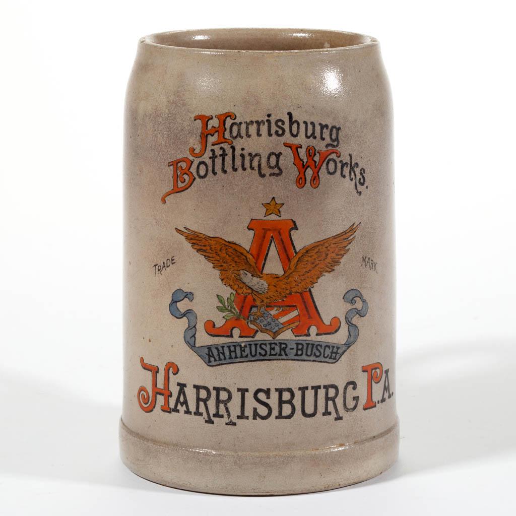 "HARRISBURG BOTTLING WORKS" ADVERTISING STONEWARE STEIN: "HARRISBURG BOTTLING WORKS" ADVERTISING STONEWARE STEIN, salt-glazed, having a polychrome hand-painted transfer design featuring the trademark "ANHEUSER-BUSCH" eagle logo to front with "Harrisburg / B