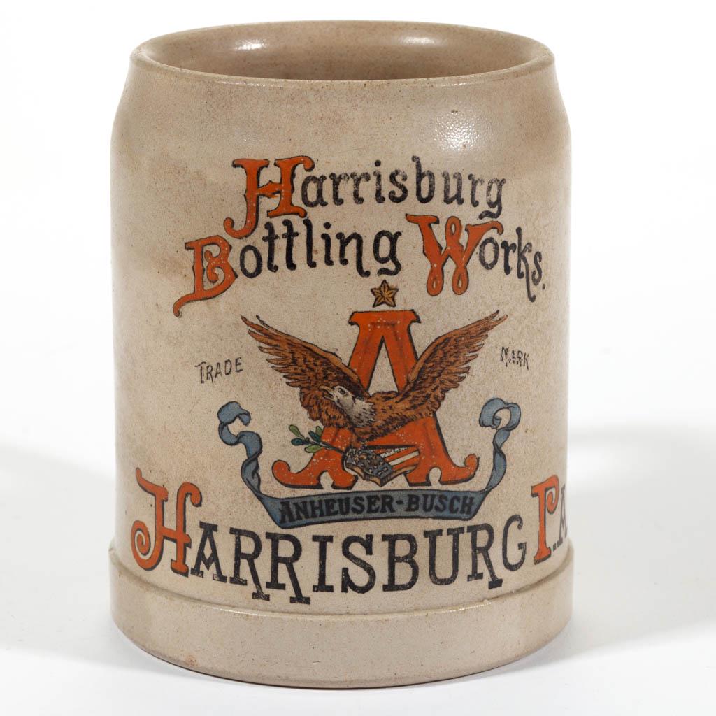 "HARRISBURG BOTTLING WORKS" ADVERTISING STONEWARE STEIN: "HARRISBURG BOTTLING WORKS" ADVERTISING STONEWARE STEIN, salt-glazed, having a polychrome hand-painted transfer design featuring the trademark "ANHEUSER-BUSCH" eagle logo to front with "Harrisburg / B