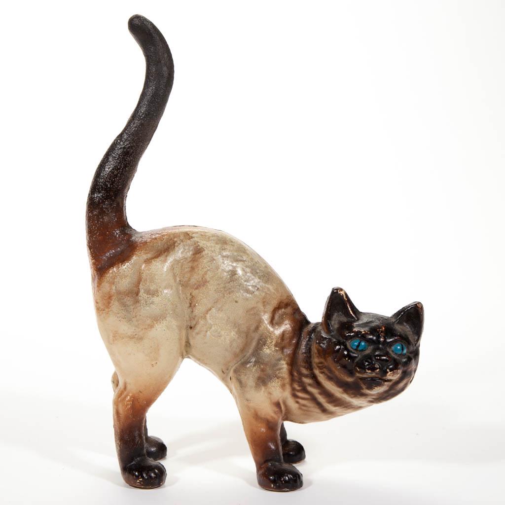 HUBLEY NO. 216 CAST-IRON FIGURAL CAT DOORSTOP / BANK: HUBLEY NO. 216 CAST-IRON FIGURAL CAT DOORSTOP/BANK, the full-figure, hollow-body form with vivid blue eyes, coin slot to back, original painted surface. Second quarter 20th century. 10 3/4" HOA, 8 1/2