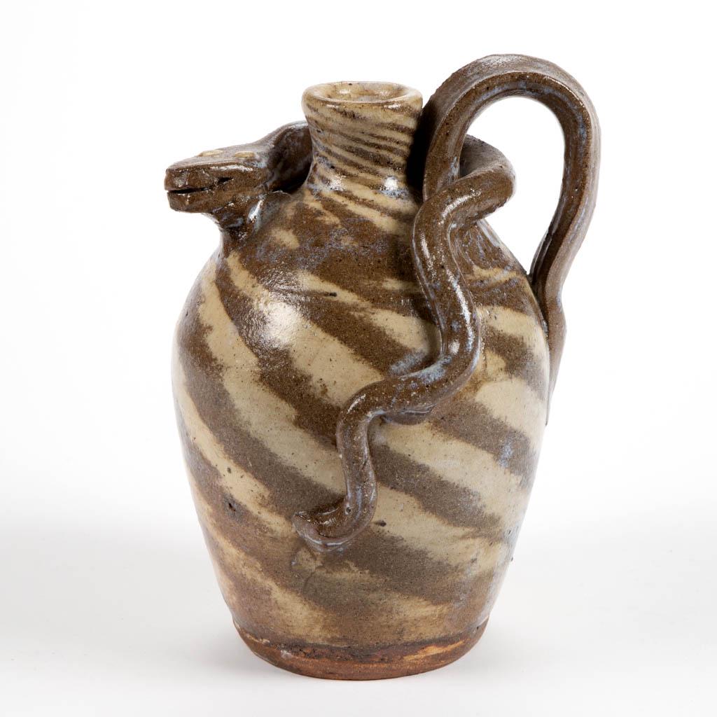 STAMPED "B.B. CRAIG / VALE, NC", NORTH CAROLINA: STAMPED "B.B. CRAIG / VALE, NC", NORTH CAROLINA SWIRL-DECORATED STONEWARE SNAKE JUG, having ovoid form with a mesmerizing applied serpent slithering through the strap handle. Stamped "B. B. Craig / Va