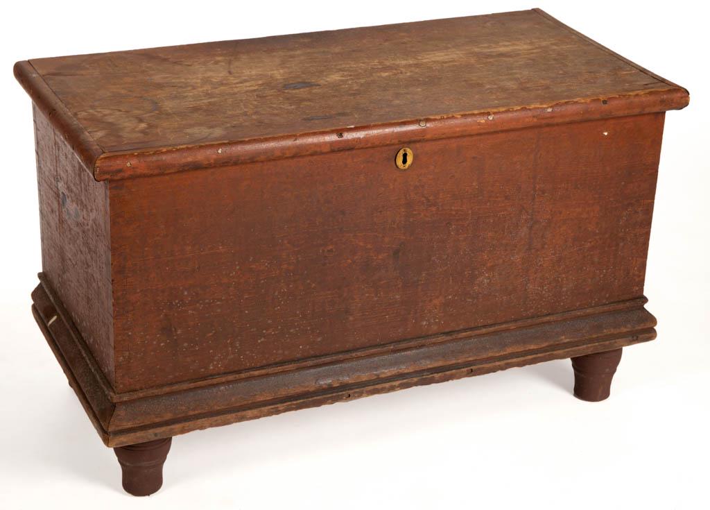 AMERICAN PAINTED PINE DIMINUTIVE BLANKET CHEST: AMERICAN PAINTED PINE DIMINUTIVE BLANKET CHEST, raised on turned feet. Old red-painted surface. 19th century. 9 1/4" H, 31 3/4" W, 15 1/2" D.Feet possibly associated or repainted.Provenance: Proceeds