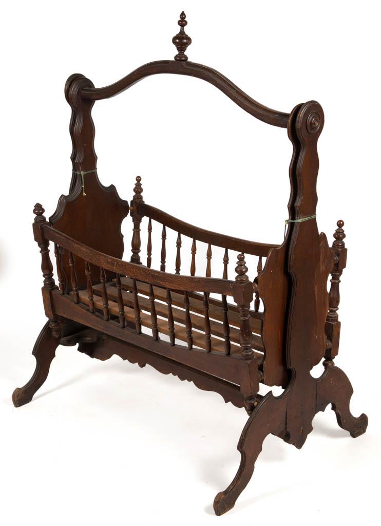 VICTORIAN WALNUT CRADLE: VICTORIAN WALNUT CRADLE, swinging, side rails featuring 11 spindles, suspended on a frame. Retains likely original varnished surface. Fourth quarter 19th/early 20th century. 56 1/2" HOA, 38 1/2" W, 19