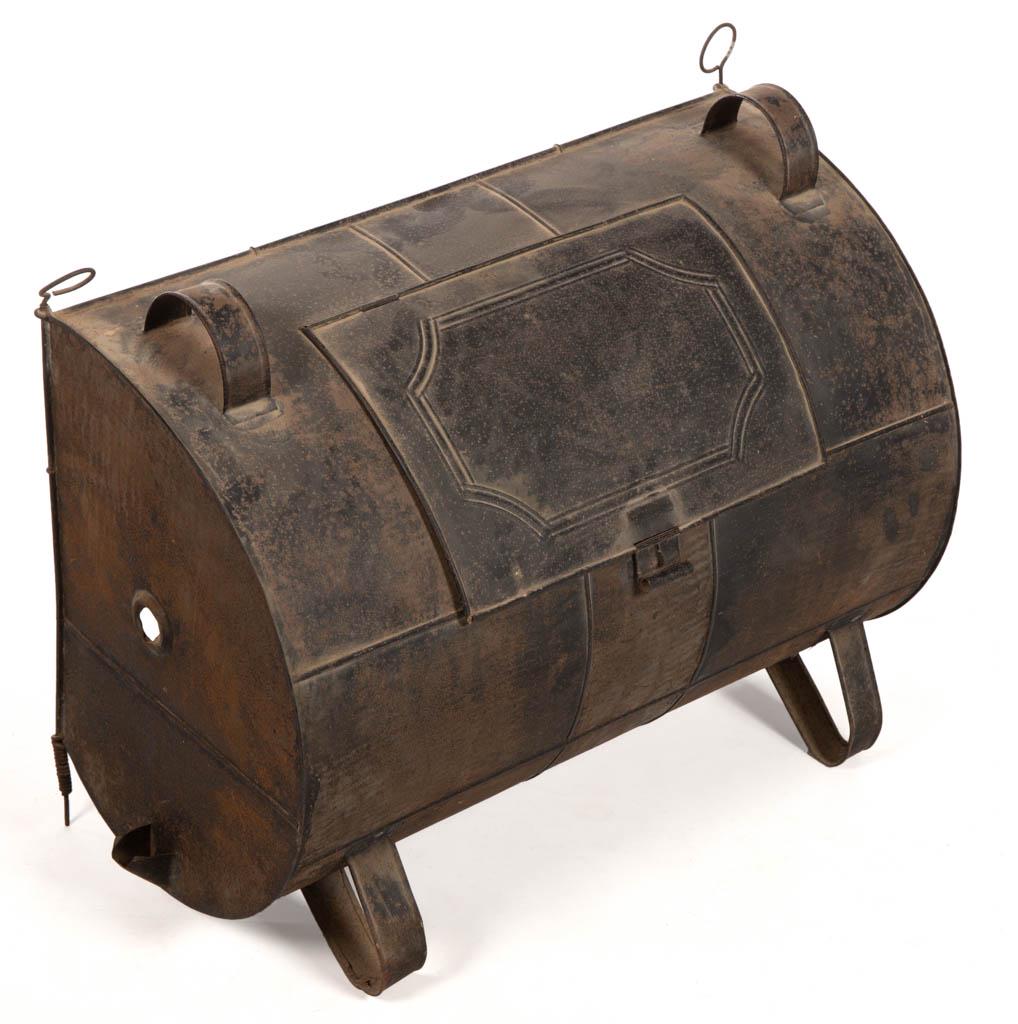 SHEET-IRON AND WROUGHT-IRON HEARTH ROASTING / REFLECTOR: SHEET-IRON AND WROUGHT-IRON HEARTH ROASTING / REFLECTOR OVEN, contoured body with open front and upper handles, hinged rear door with simple stylized rib pattern, supported by strap legs to the revers