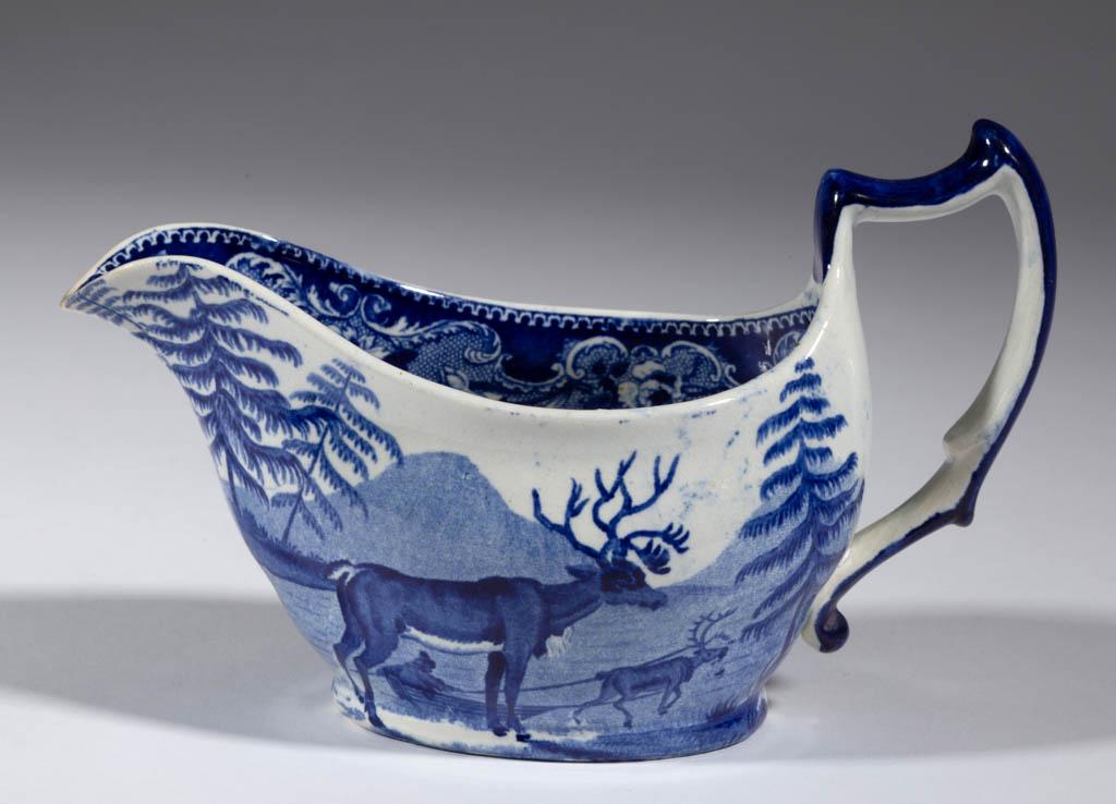 ENGLISH STAFFORDSHIRE PEARLWARE BLUE TRANSFER-PRINTED: ENGLISH STAFFORDSHIRE PEARLWARE BLUE TRANSFER-PRINTED "REINDEER" CERAMIC SAUCE BOAT, featuring an antlered stag in foreground with image of another reindeer pulling a figure in a flat-bottomed boat or