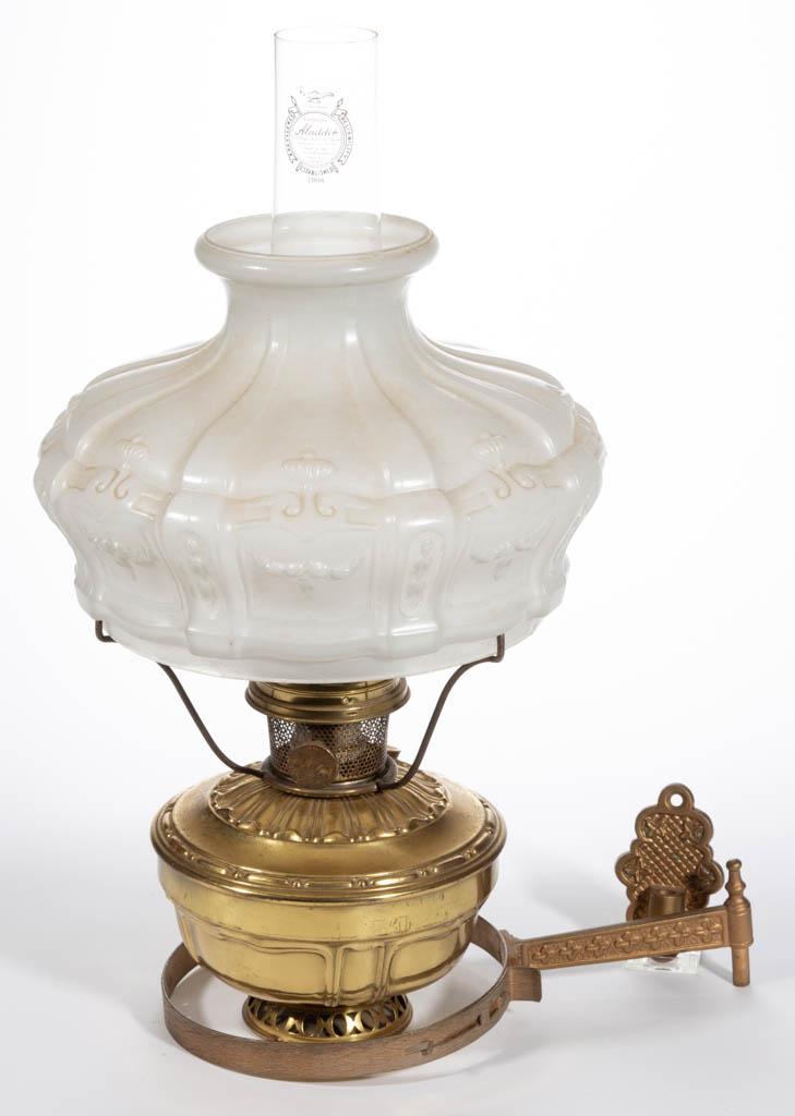 ALADDIN MODEL 8 BRASS KEROSENE BRACKET LAMP: ALADDIN MODEL 8 BRASS KEROSENE BRACKET LAMP, two-piece wall fixture with a stamped foliate band. Fitted with a Model 8 font tank and Model 8 burner with correct flame spreader, brass spider shade ring