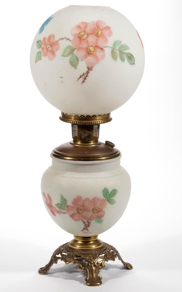 GONE WITH THE WIND KEROSENE PARLOR LAMP: GONE WITH THE WIND KEROSENE PARLOR LAMP, opaque white with polychrome-enamel decoration, ovoid font vase raised on a brass foot numbered "232" to the underside, matching decoration to ball shade being