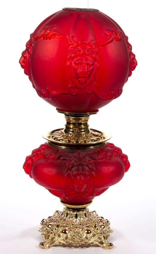 CONSOLIDATED LION KEROSENE GONE WITH THE WIND / PARLOR: CONSOLIDATED LION KEROSENE GONE WITH THE WIND / PARLOR LAMP, Ruby satin, matching patterned ball-form shade, compressed form font vase with figural lion's heads, metal liner and brass spill ring, cast