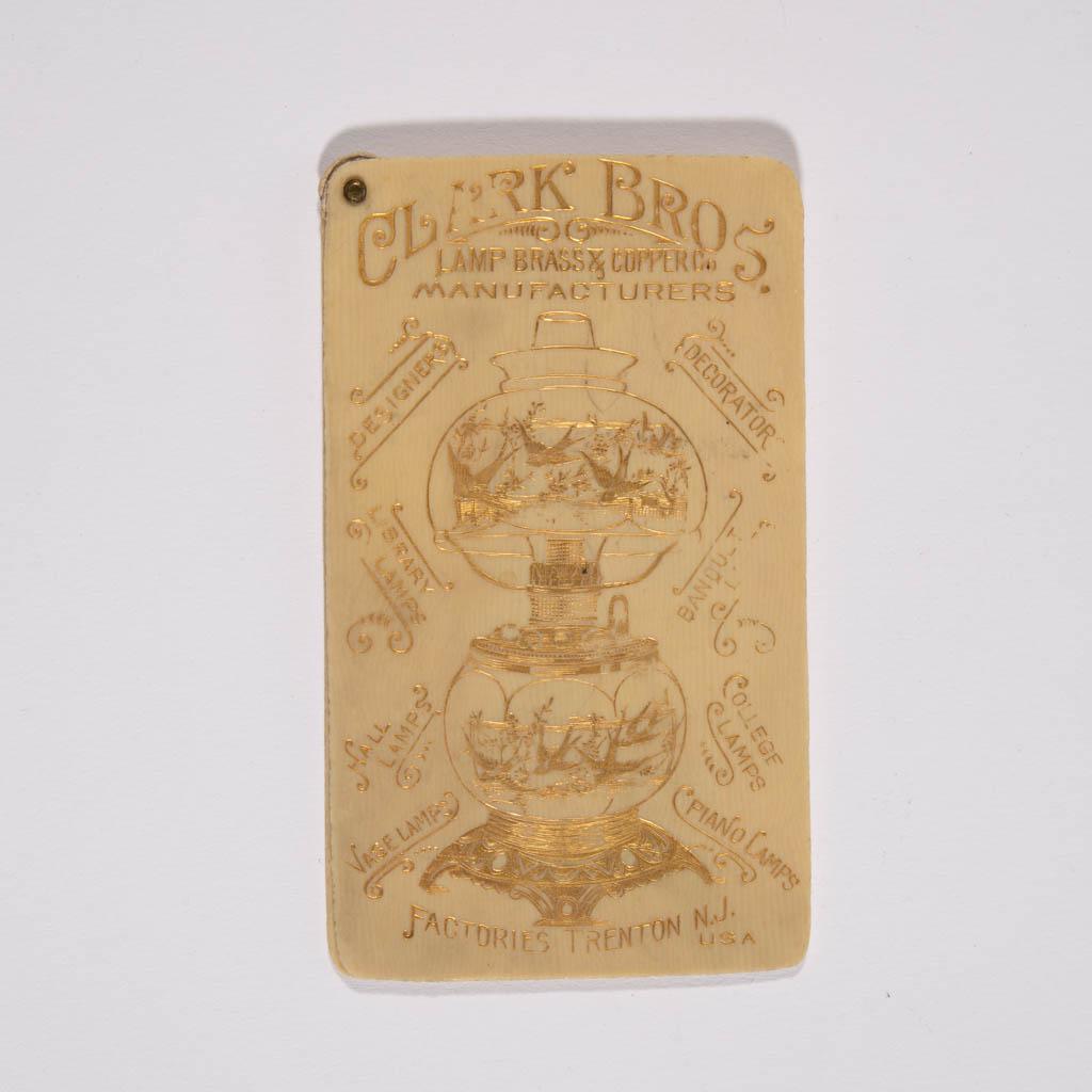 CLARK BROTHERS LAMP BRASS & COPPER CO. MANUFACTURERS: CLARK BROTHERS LAMP BRASS & COPPER CO. MANUFACTURERS POCKET CALENDAR, gilt lithography on composition material, featuring a central Gone-with-the-Wind lamp with bird decoration. Original issue. 1892. 