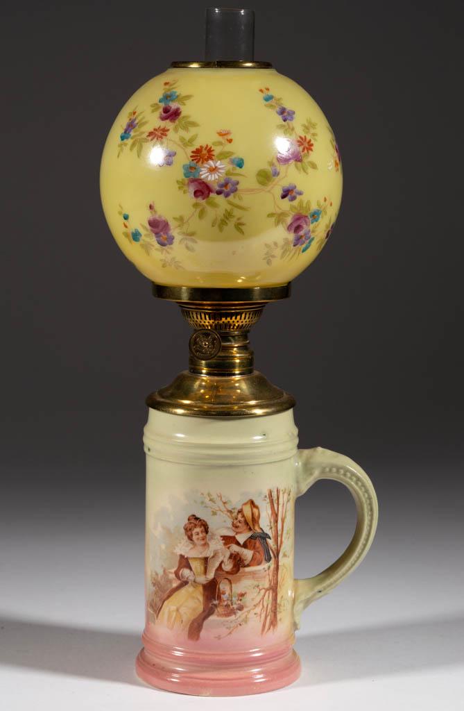 VICTORIAN DECORATED CERAMIC FIGURAL STEIN MINIATURE: VICTORIAN DECORATED CERAMIC FIGURAL STEIN MINIATURE FINGER LAMP, tan ground with polychrome transfer decoration, decoration depicting a man and woman in a romantic scene, brass drop-in font, underside