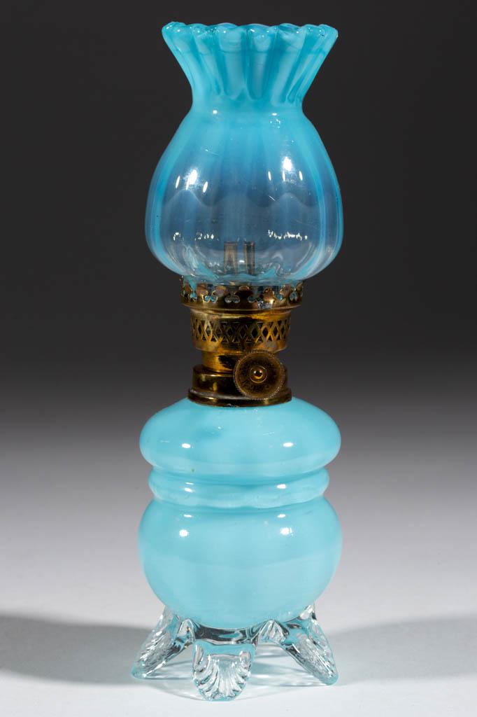 PANEL-OPTIC ART GLASS MINIATURE LAMP: PANEL-OPTIC ART GLASS MINIATURE LAMP, blue with light opalescence, globular-form font with double-ringed shoulder, colorless applied base raised on five toes, each with a pressed rib pattern, matching