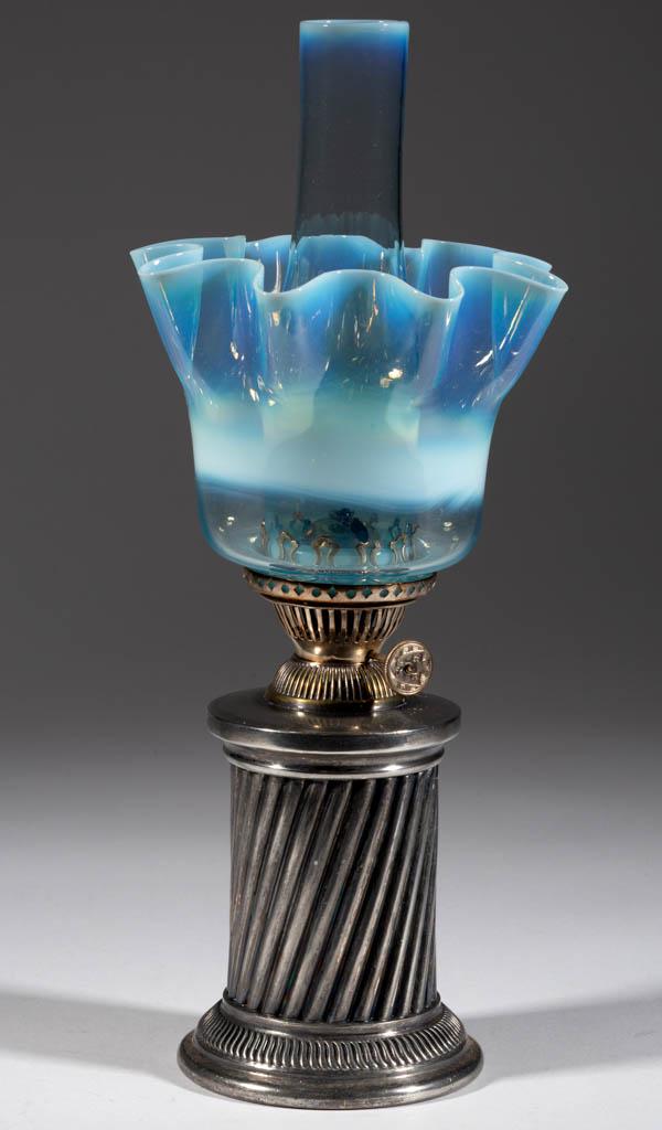 SILVER-PLATED SWIRLED RIB MINIATURE LAMP: SILVER-PLATED SWIRLED RIB MINIATURE LAMP, cylinder-form font and circular-form base, pale blue opalescent cylinder-form shade with flared-out scalloped rim and a single horizontal opalescent band, per