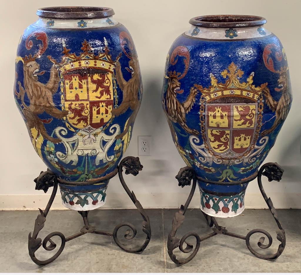 SPANISH MAJOLICA EARTHENWARE PAIR OF MONUMENTAL OIL JAR: SPANISH MAJOLICA EARTHENWARE PAIR OF MONUMENTAL OIL JAR URNS WITH STANDS, each having bold polychrome hand-painted decorations, one side featuring two crowned lions flanking a coat of arms depicting t