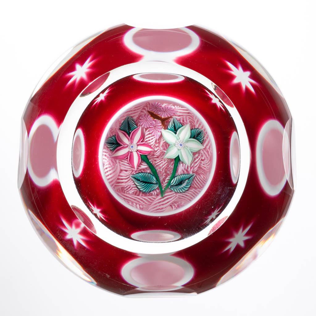 JOHN DEACONS DOUBLE-OVERLAY ENCASED LAMPWORK STUDIO ART: JOHN DEACONS DOUBLE-OVERLAY ENCASED LAMPWORK STUDIO ART GLASS PAPERWEIGHT, colorless, interior red to white to colorless with cut circles and stars to the red surface, white and red lace ground with a