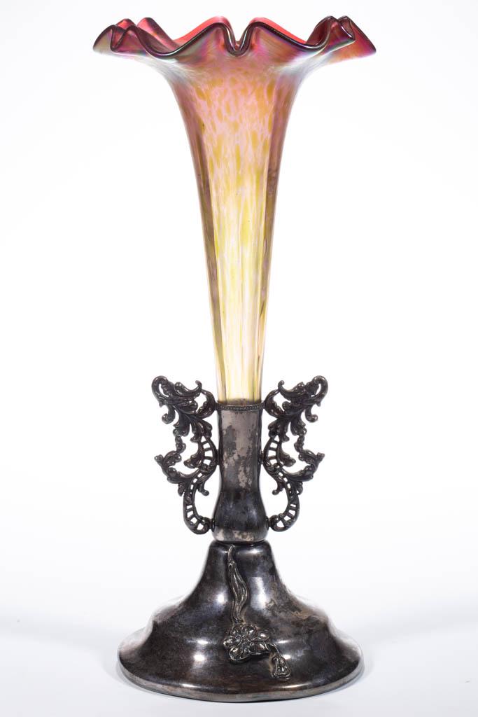 RINDSKOPF ATTRIBUTED GRENADA IRIDESCENT ART GLASS: RINDSKOPF ATTRIBUTED GRENADA IRIDESCENT ART GLASS EPERGNE, cranberry and mottled green iridescent, trumpet vase with eight concave ribs, fitted into a quadruple-plate stand with openwork scrolling han