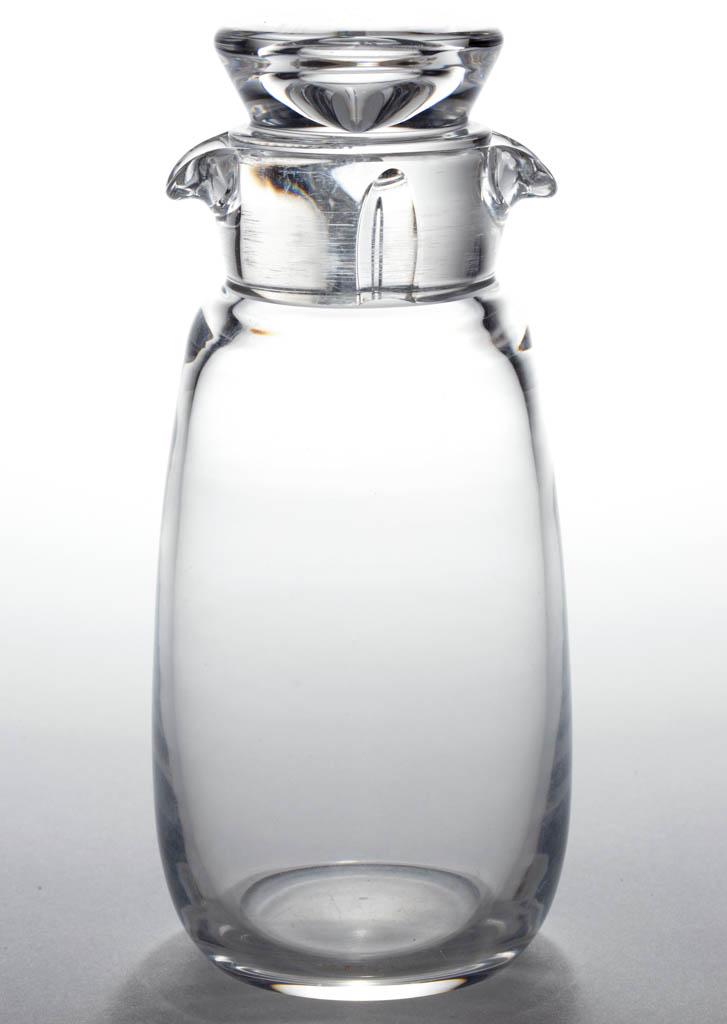 STEUBEN CRYSTAL ART GLASS COCKTAIL SHAKER: STEUBEN CRYSTAL ART GLASS COCKTAIL SHAKER, colorless, ovoid form with rim having two tooled spouts, original stopper with two concave notches to the extension, signed "STEUBEN" to the underside. Steub