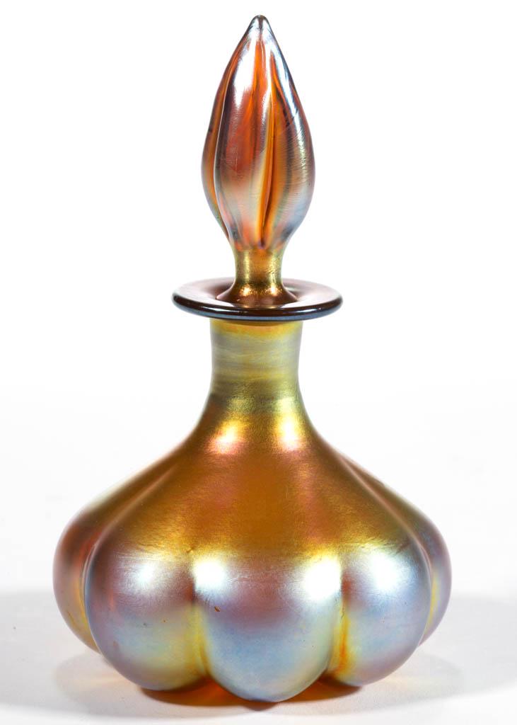 STEUBEN AURENE IRIDESCENT ART GLASS PERFUME BOTTLE: STEUBEN AURENE IRIDESCENT ART GLASS PERFUME BOTTLE, Gold Aurene, shape 1455, original stopper, signed "AURENE" to the underside. Steuben Glass Works. Circa 1924. 4 3/4" HOA, 2 3/4" H bottle. Undamaged