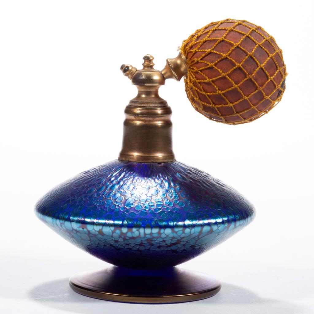 LOETZ ATTRIBUTED PAPILLON IRIDESCENT ART GLASS ATOMIZER: LOETZ ATTRIBUTED PAPILLON IRIDESCENT ART GLASS ATOMIZER, blue iridescent, compressed bladed form with an applied circular foot, period mount, top, and bulb apparatus. Bohemia, now Czech Republic. Firs