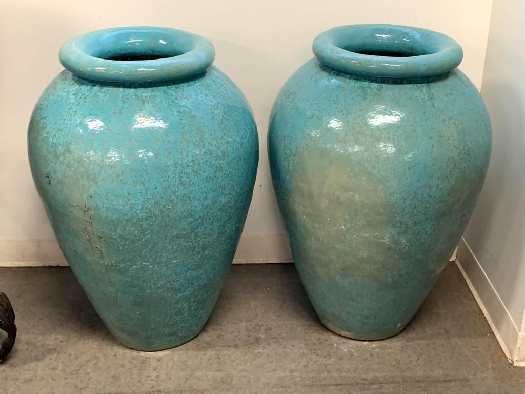 GLADDING MCBEAN ART POTTERY PAIR OF MONUMENTAL OIL JAR: GLADDING MCBEAN ART POTTERY PAIR OF MONUMENTAL OIL JAR URNS, each having rich turquoise glaze with broad rounded rim and central drainage hole. Gladding McBean Pottery, Lincoln, CA. Mid 20th century. 