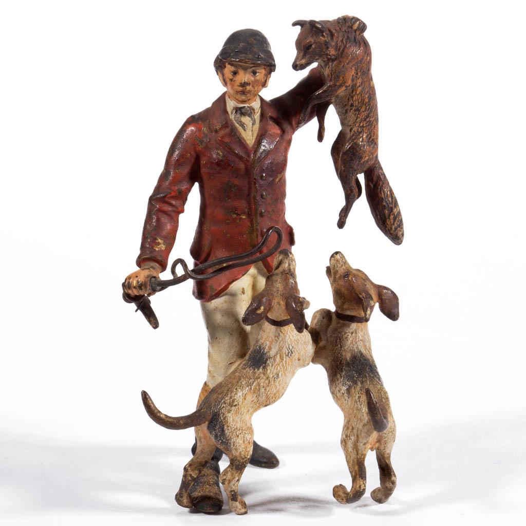 FRANZ BERGMAN (AUSTRIAN, 1898-1963) COLD-PAINTED VIENNA: FRANZ BERGMAN (AUSTRIAN, 1898-1963) COLD-PAINTED VIENNA BRONZE FIGURAL GROUP, fox hunter holding captured fox aloft with eager dogs at his feet, marked to bellies of dogs, consisting of a "B" within a